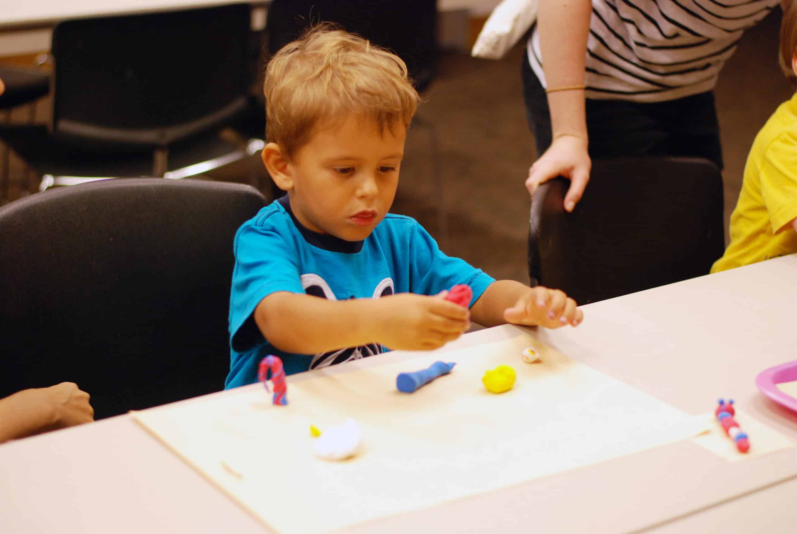 child playing with clay at the museum's Tot Time program