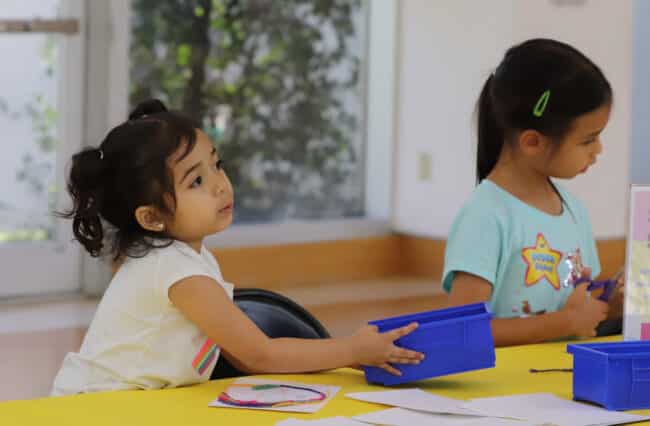 child holding box of art supplies at Art Cart