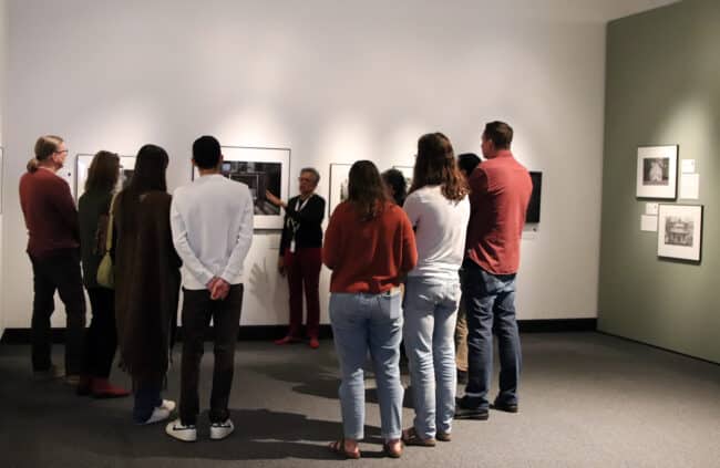 Harn docent discussing a photograph with guests in the Bishop Gallery