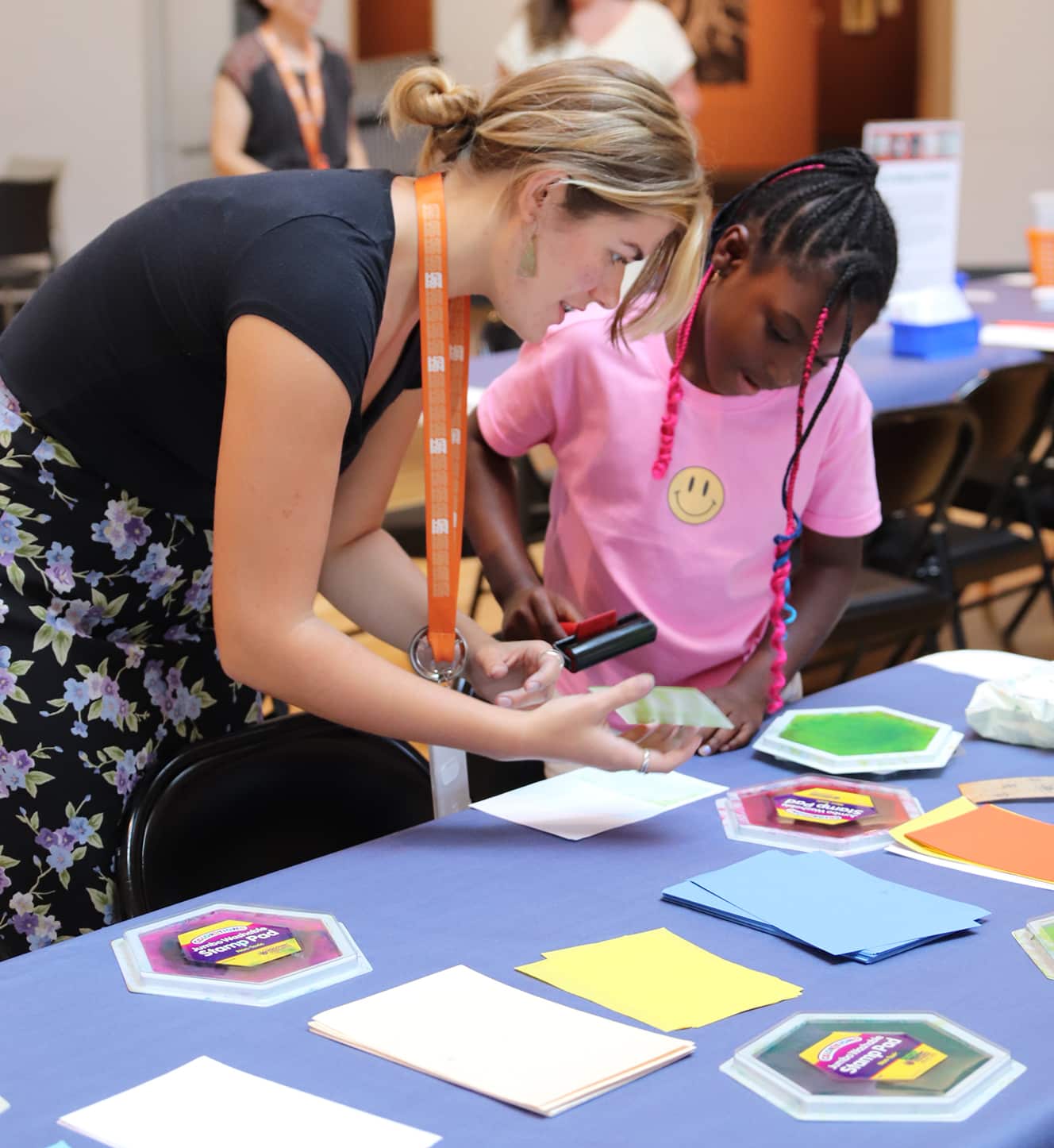 A Harn intern helps a visitor with materials at the Art Cart