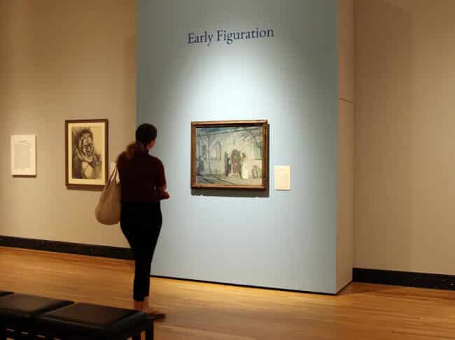 Museum visitor looks at a painting on the wall in the "Silver Linings" exhibition