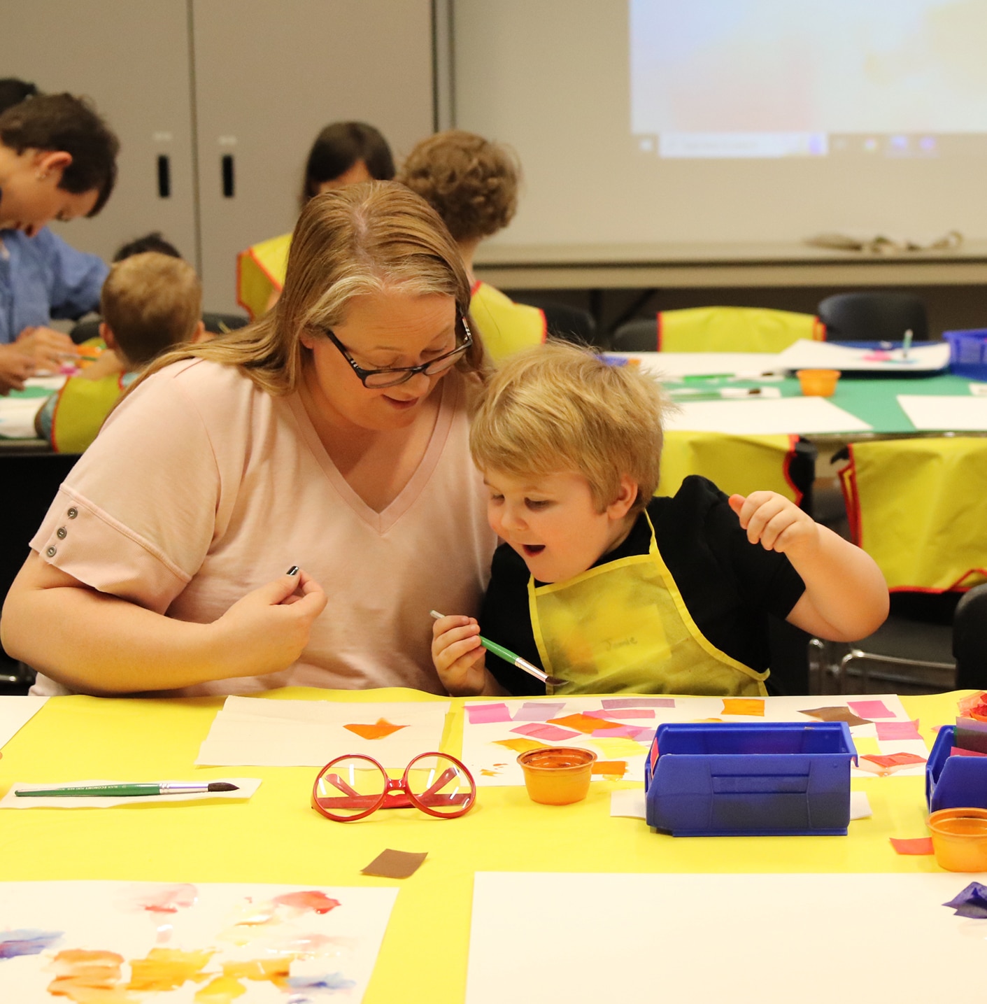 An adult an child making art during Tot Time