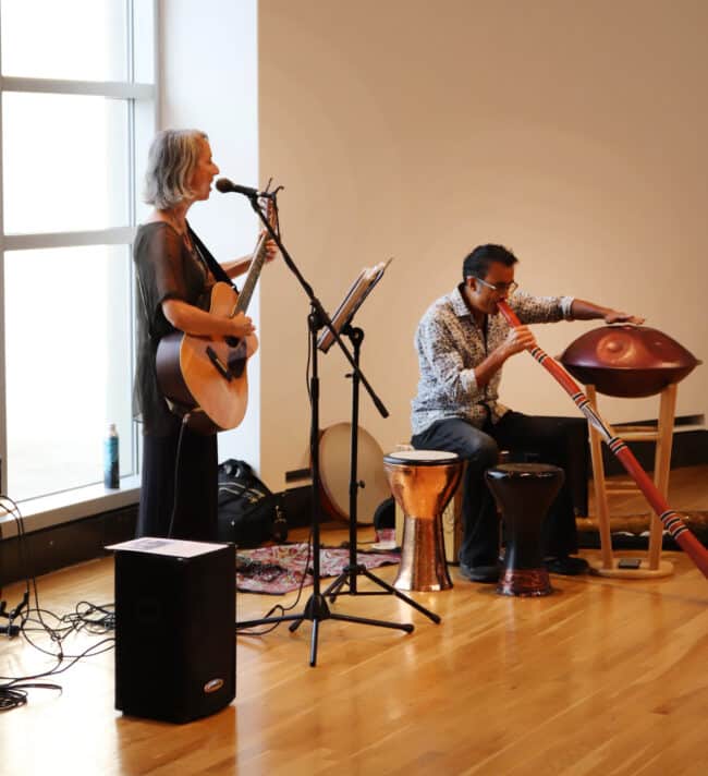 photograph of Shana Smith and Raihan Alam playing musical instruments in the rotunda