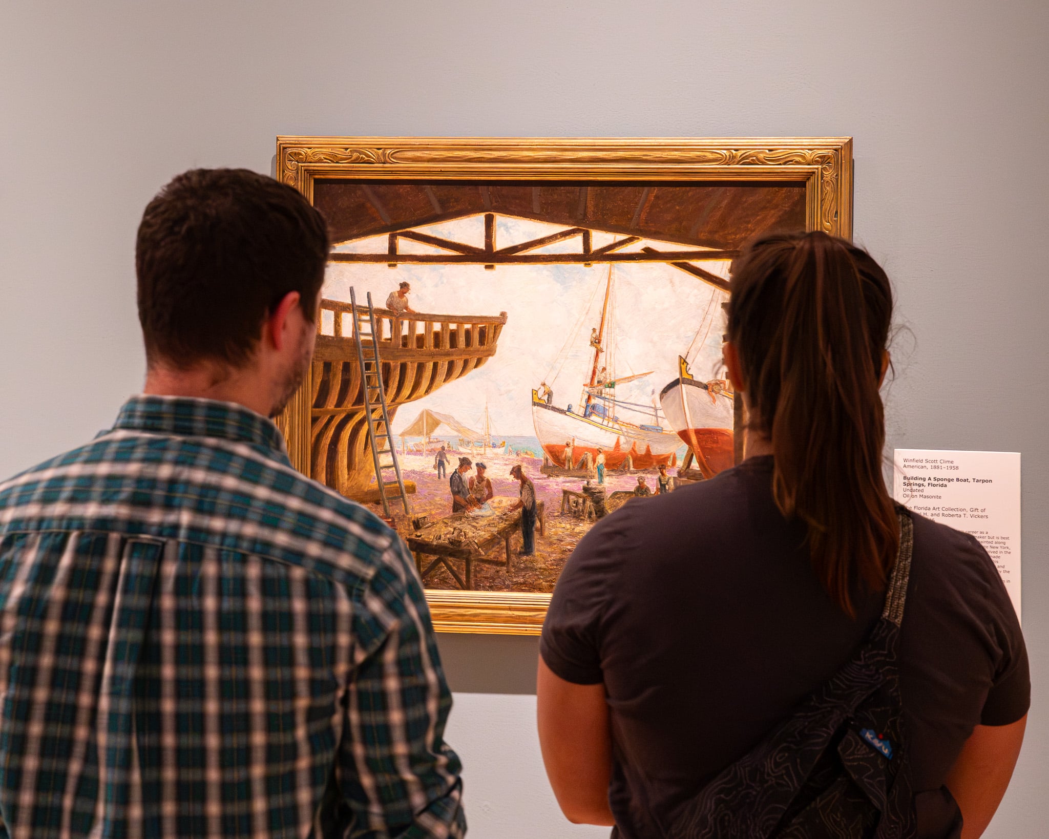 People looking at a painting.