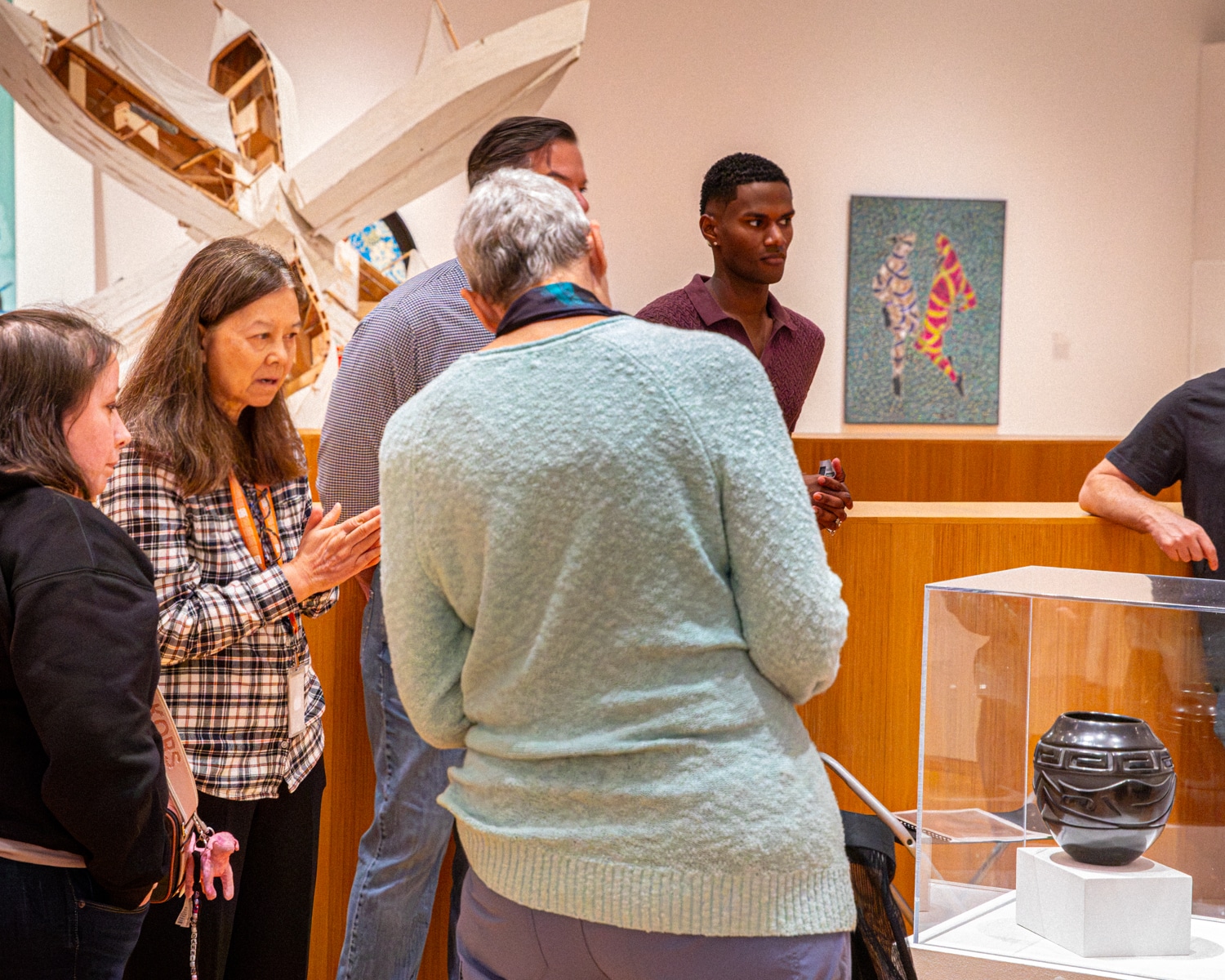 Group of people listening to a Harn Docent give a tour in the "Metamorphosis" exhibition.